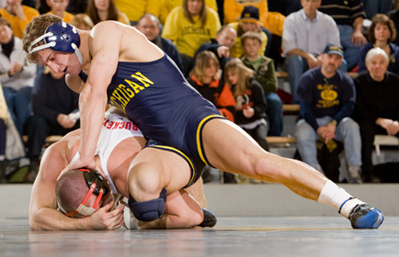 Wrestler Steve Luke pushes down on the head of an Ohio State wrestler