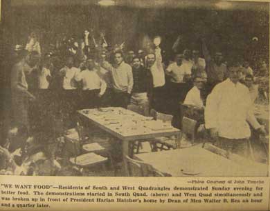 A 1956 newspaper photo showing a crowd of men raising their fists in protest in a cafeteria.