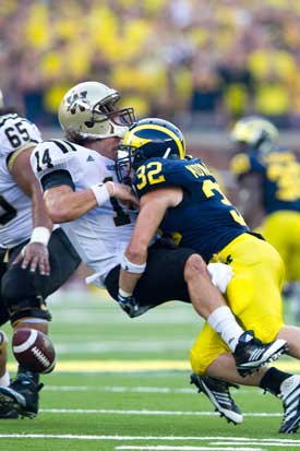 Jordan Kovacs (32), who went from failed walk-on to defensive superhero, is the exception that proves the rule: most walk-ons rarely get to play, much less star, on Saturdays. (Photo: Eric Bronson, U-M Photo Services.)