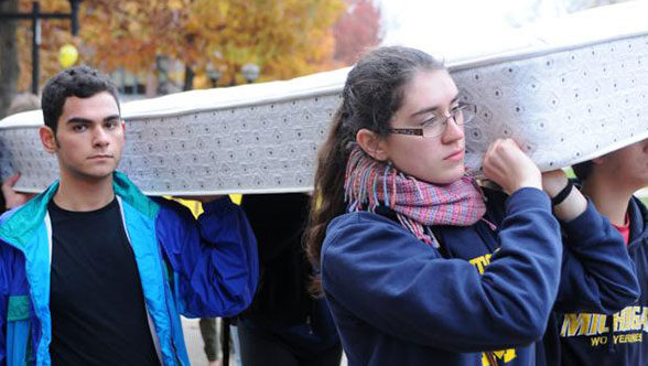 Students carry a mattress to challenge to sexual misconduct policies