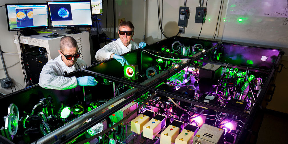 Anatoly Maksimchuk, EECS research scientist, and John Nees, EECS associate research scientist, demonstrate use of the HERCULES 300 TW laser in the Carl A. Gerstacker Building in September 2017. (Image: Joseph Xu.)