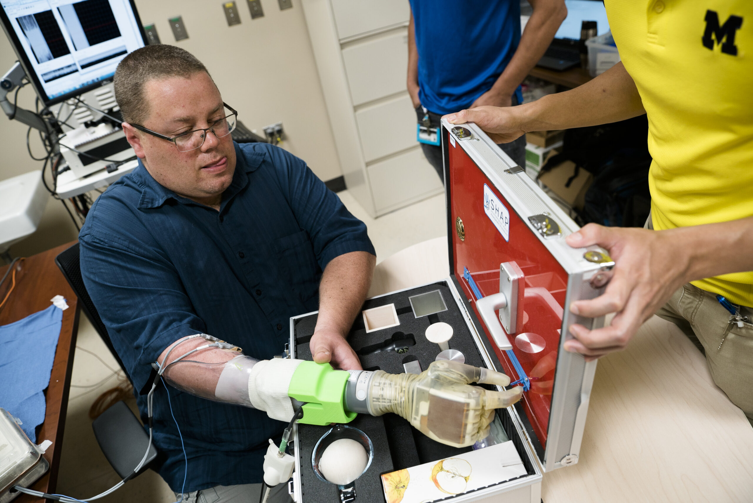 Joe Hamilton, a participant in the University of Michigan RPNI study, naturally uses his mind to control a DEKA prosthetic hand to pinch a small zipper on a hand development testing platform.