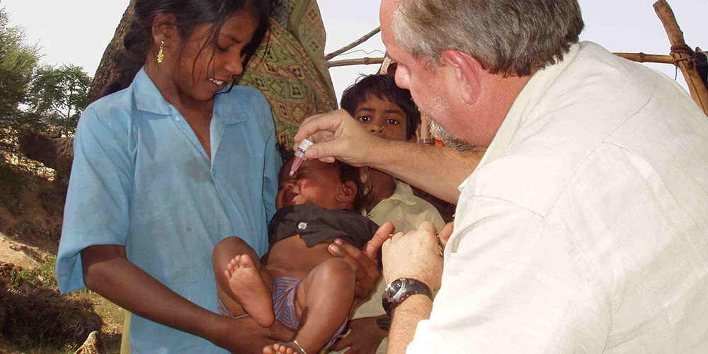 Dr Larry Brilliant gives polio drops to baby