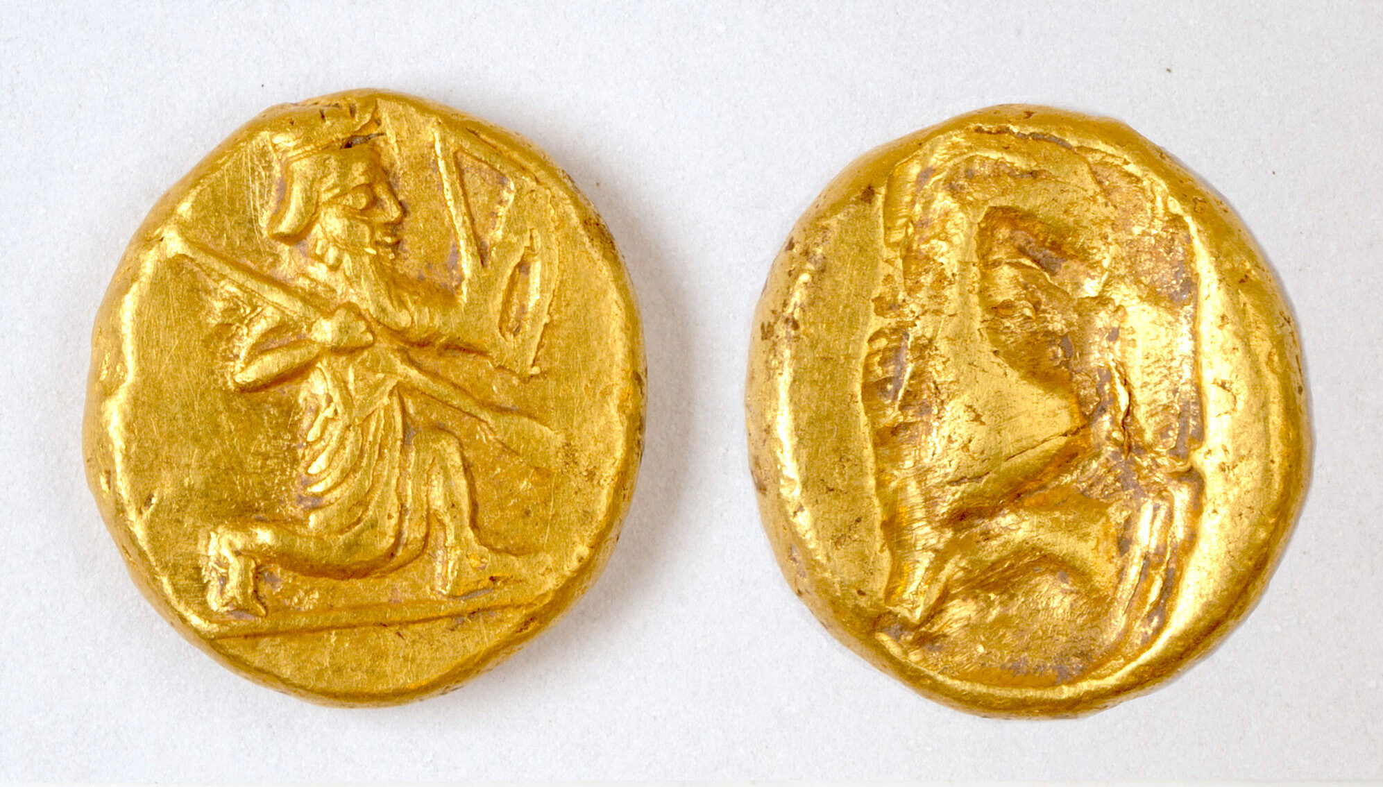 Two ancient gold coins with images of an archer.