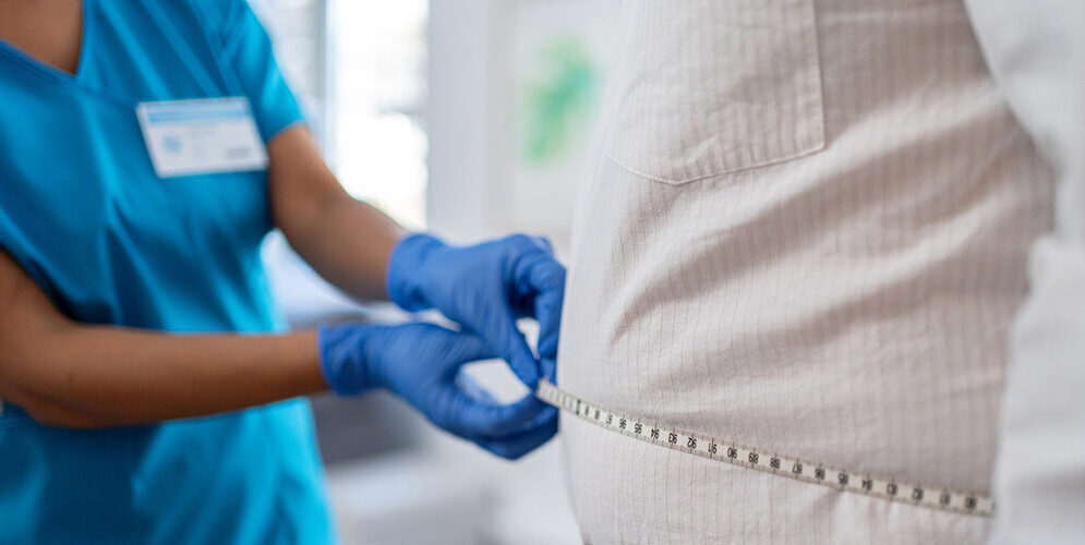 Doctor measures a person's girth using a measuring tape to determine if the person is a candidate for weight-loss drugs like Ozempic and Wegovy.